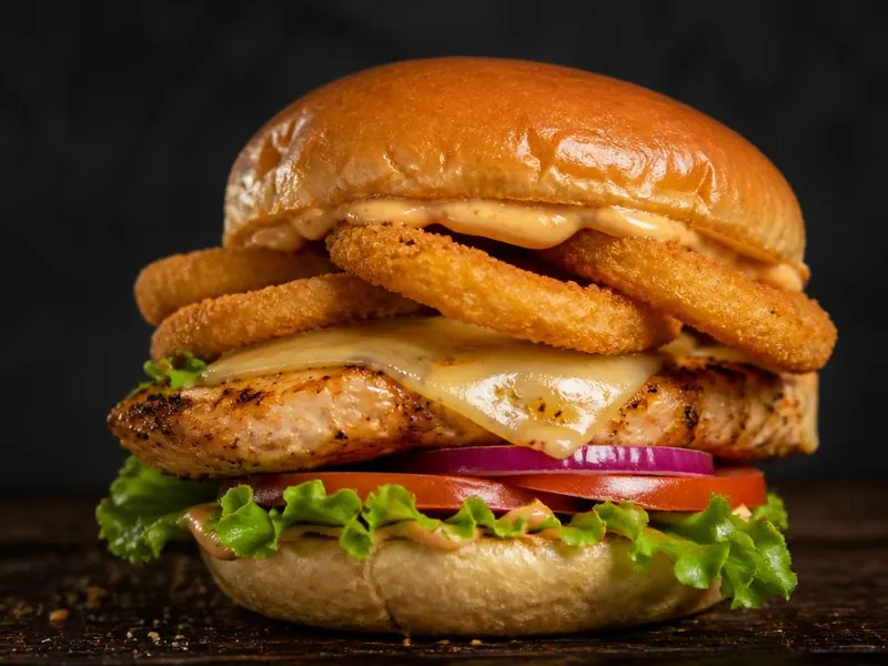 Hambúrguer Frango Supremo com bife de frango grelhado, queijo, onion rings e alface